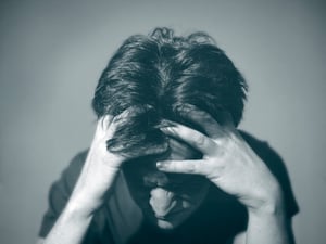 stressed person with head in hands