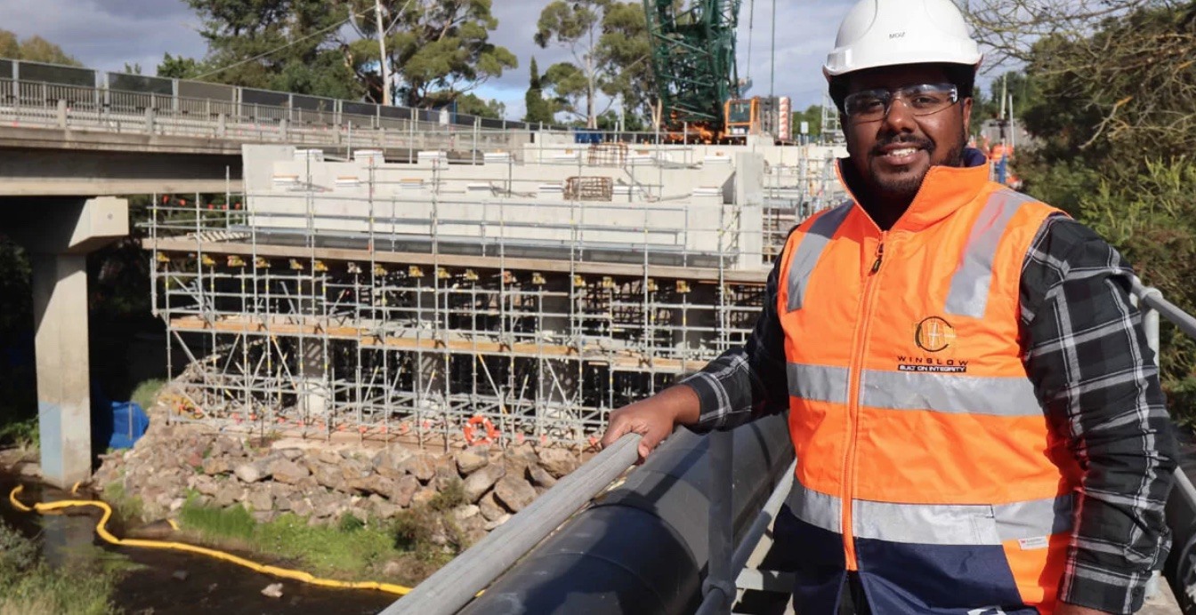 Construction Worker smiling in front of form work for new bridge