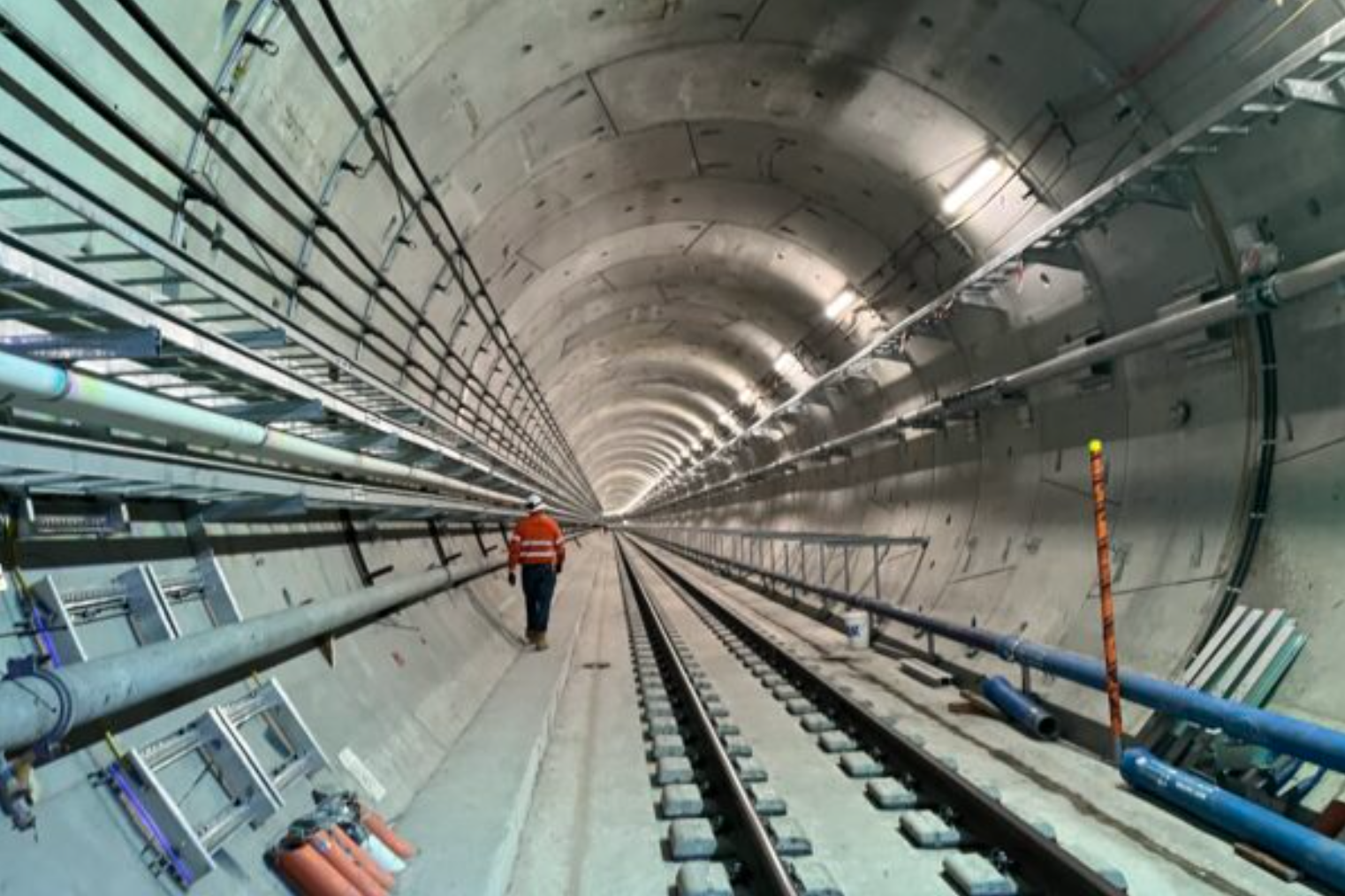 Worker inspecting new rail underground tunnel